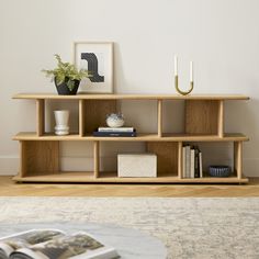 a living room with a book shelf and vases on top of the shelves next to a coffee table