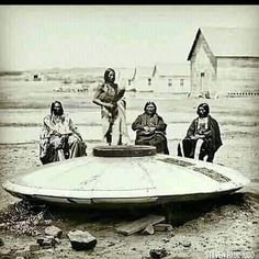 an old black and white photo of native americans sitting on a boat in the desert