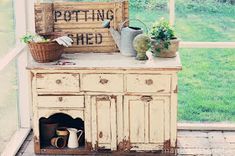 an old dresser with potting plants on top