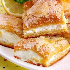 several pieces of cake on a plate with lemon wedges and mint sprig