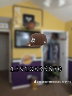 a baseball cap flying through the air in a room with yellow walls and purple cabinets