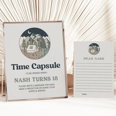 a sign that says time capsule next to a postcard and notepad on a table