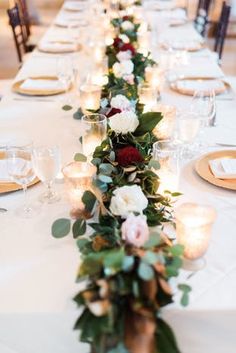 a long table with candles and flowers on it