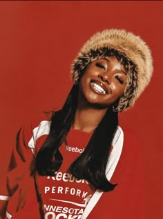 a woman wearing a red shirt and a furry hat