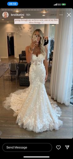 a woman taking a selfie while wearing a wedding dress in front of a mirror