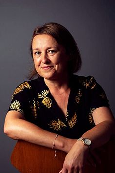 a woman sitting in a chair with her arms crossed and looking off to the side