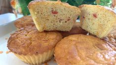 several muffins on a plate with one cut in half