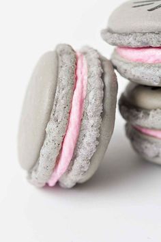 three macaroons with pink and white frosting on them