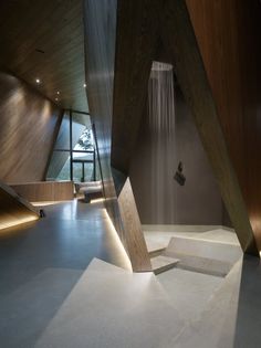 an image of a room with wooden walls and stairs in the center, as well as water flowing from the ceiling