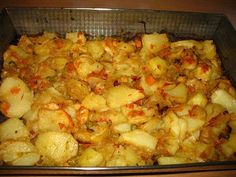 a pan filled with potatoes sitting on top of a wooden table