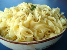 a white bowl filled with pasta on top of a blue table