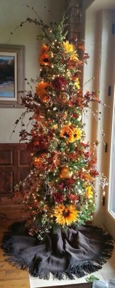 a christmas tree decorated with sunflowers and other flowers is shown in an instagram