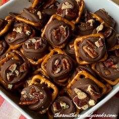 chocolate pretzels with pecans and nuts in a white dish on a checkered tablecloth