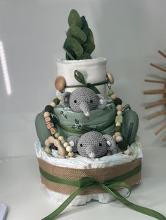 a crocheted cake with two elephants on top and green ribbon around the bottom