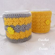 two crocheted coffee mugs sitting next to each other on a white table