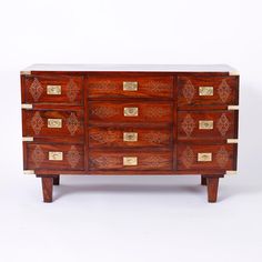 an old wooden dresser with many drawers and gold hardware on the top, against a white background