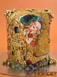 a close up of a vase with a woman on it's face and gold trimmings