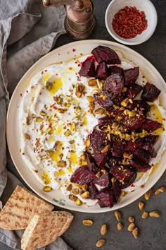 beets and yogurt on a plate with toasted crackers next to it