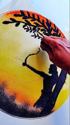 a person is painting on the side of a car with orange and black paint that looks like a tree