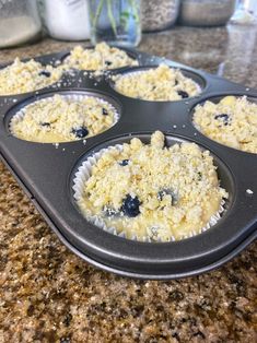 a muffin tin filled with blueberries on top of a counter