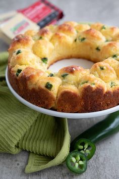 a bundt cake sitting on top of a white plate next to a green pepper