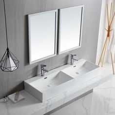 two white sinks sitting under mirrors in a bathroom