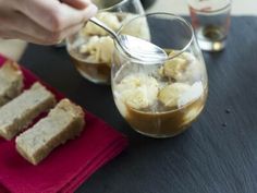 someone is pouring syrup into some desserts on a table