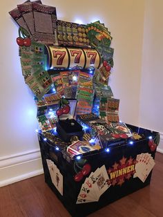 a casino machine with lots of cards and lights on it's display stand next to a wall