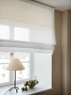 a lamp sitting on top of a window sill next to a white table cloth