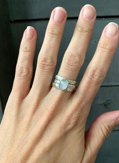 A stunning oval white moonstone has been set in sterling silver with two accenting ring bands! This lovely moonstone stone is 10mm x 8mm in size. It has been set in sterling silver with a handmade ring band from 3mm sterling silver rectangle wire. Each ring band has been hand hammered. Wear all three together as a stacked ring or separately. Made to order! Choose your size and gemstone! Moonstone, pink chalcedony, white howlite, aqua chalcedony, and green prehnite!Also available in a horizontal Silver Stackable Moonstone Ring For Anniversary, Stackable Silver Moonstone Ring For Anniversary, Silver Moonstone Stackable Rings, White Stackable Moonstone Rings With Ethical Gemstones, Oval Moonstone Gemstone Stackable Rings, Oval Moonstone Stackable Rings With Gemstone, White Moonstone Stackable Rings For Promise, Oval Moonstone Stackable Ring For Anniversary, Silver Moonstone Stackable Rings For Anniversary