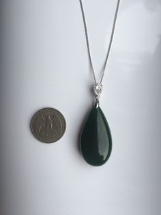 A gorgeous dark green jade pendant necklace. The big teardrop pendant comes with shiny diamond-like small teardrop stones and a 925 sterling silver necklace. Simple but elegant. Perfect as a gift for yourself or your loved ones. Highlights of this breath-taking teardrop round jade pendant are: ＊High-quality materials Made from quality jade and 925 sterling silver. Friendly to sensitive skins and ensure long-lasting color ＊Simple & Elegant Minimalistic style goes well with all sorts of occasi Elegant Green Pendant Drop Necklace, Elegant Green Gemstone Drop Necklace, Elegant Dark Green Jade Jewelry, Green Teardrop Gemstone Drop Necklace, Elegant Jade Drop Jewelry, Elegant Teardrop Jade Jewelry, Green Jade Teardrop Pendant Jewelry, Jade Teardrop Pendant Gemstone Jewelry, Green Jade Necklace