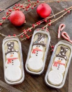 three tins with snowman cookies in them