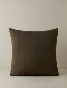 a brown pillow sitting on top of a white table