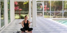 a woman sitting on the floor in front of a swimming pool