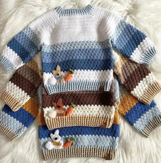 a knitted sweater with animals on it sitting on a white furnishing area