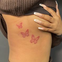 a woman's stomach with three butterflies tattooed on her belly and the bottom part of her lower back