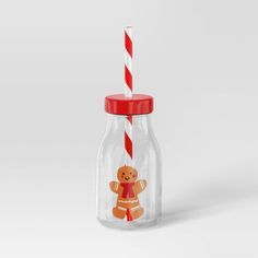 a glass jar with a red and white striped straw in the shape of a gingerbread man