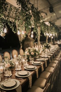 a long table is set with plates and place settings for an elegant dinner party or wedding reception