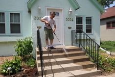 a man is washing the steps outside of a house with a pressure washer on it