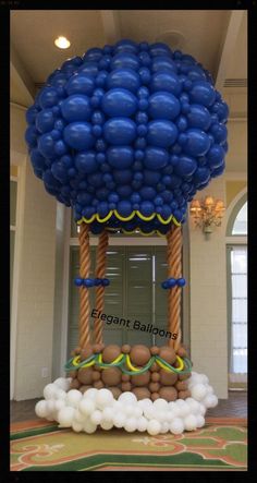 an inflatable balloon tree is on display at the entrance to a building with balloons all around it