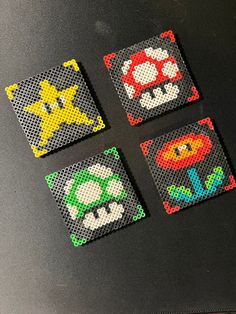 four different designs are shown on a black surface, one is made out of perler beads