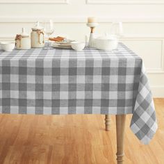 the table is covered with a checkered tablecloth and dishes on it, along with two candles