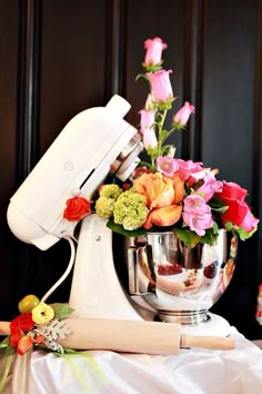 a mixer filled with flowers on top of a table