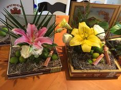 two vases filled with flowers on top of a wooden table