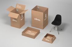 an open cardboard box sitting on top of a white floor next to a black chair