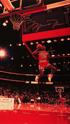 a basketball player jumping up into the air to dunk a ball in front of an audience