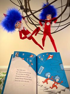 two dr seuss and the cat in the hat stuffed animals hanging from a book