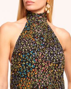 Frame your face in florals with the Eileen, a dramatic halter top here to make outfit look blossom. Adorned with a multicolored garden print that enhances the sleeveless silhouette, give this sweet style a spin to reveal the contemporary open back.Size & Fit – Fits true to size, take your normal size – Model is Wearing Size XS – Model is 5'9" Size Guide Details & Care – Lined– Adjustable halter neckline – Sleeveless – Full length – Open back– Dry Clean or Hand Wash– Style #: A04241013– 100% Visc Chic Floral Print Halter Top, Floral Print Halter Neck Top For Party, Fitted Multicolor Floral Print Halter Top, Sleeveless Floral Print Halter Top For Spring, Chic Fitted Floral Halter Top, Black Halter Neck Top For Spring, Fitted Floral Print Halter Top, Fitted Floral Print Halter Neck Top, Spring Floral Print Fitted Halter Top