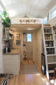 a tiny kitchen with stairs leading up to the loft