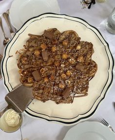 a white plate topped with waffles covered in chocolate